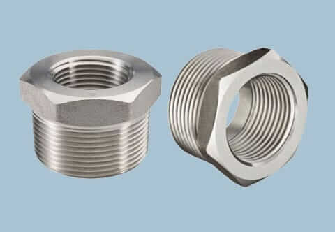 Two stainless steel hex bushings on a light blue background