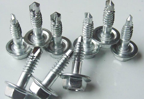 A close-up image of several silver, hexagonal self-drilling screws with washers